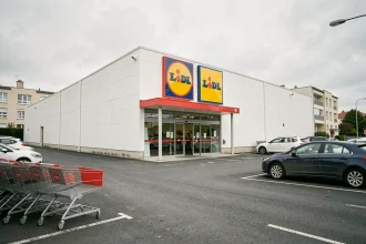 Façade extérieure d'un supermarché Lidl avec parking en zone périurbaine française